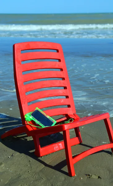 Стілець на пляжі зі смартфоном — стокове фото