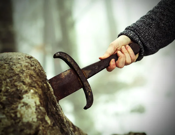 Cavaleiro tenta remover a espada Excalibur na pedra — Fotografia de Stock