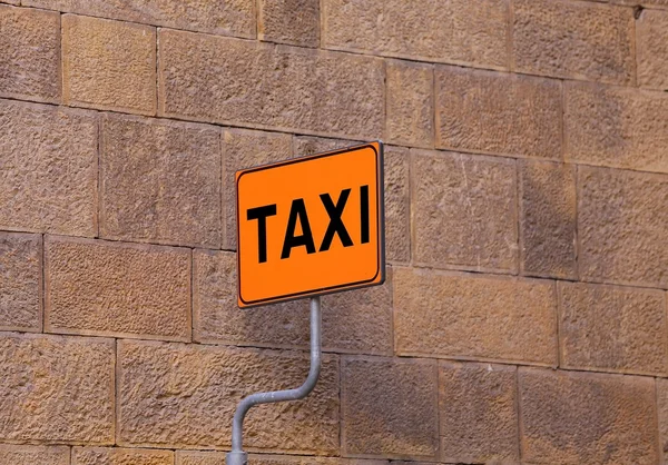 Señal TAXI en la parada de taxi con una pared como fondo — Foto de Stock