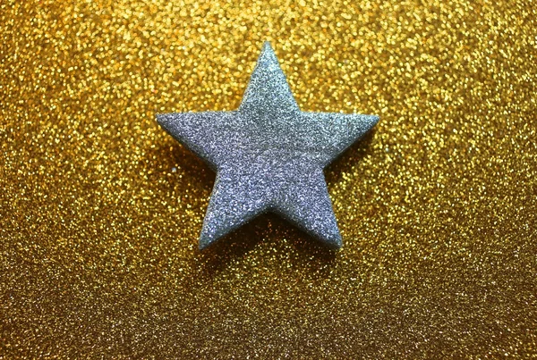 Heldere zilveren ster op gouden achtergrond — Stockfoto