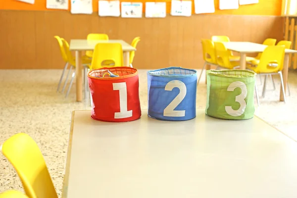 Drei Behälter für Spielzeug mit den Zahlen eins zwei drei in einer Klasse — Stockfoto