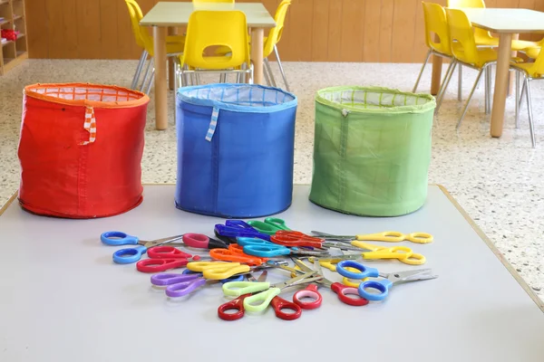 Três recipientes de tecido coloridos para brinquedos e muitas tesouras em — Fotografia de Stock