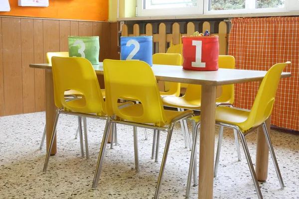 Aula de jardín de infantes con las sillas amarillas y pequeñas mesas —  Fotos de Stock