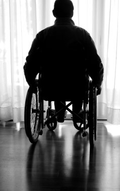 pencerenin yakınındaki odasında tekerlekli sandalyede devre dışı