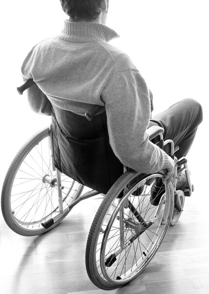 disabled sitting in a wheelchair in the room near the window