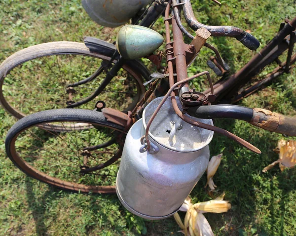 Два древних ржавых велосипеда для перевозки молока в мусорное ведро — стоковое фото