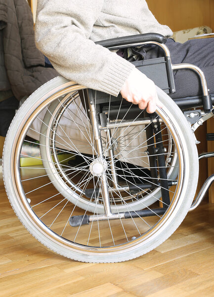 hand of the young disabled in the wheel of the wheelchair