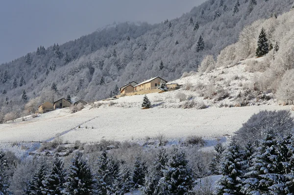 Távoli hegyi falu, a tetejét a hóval borított hegyek — Stock Fotó