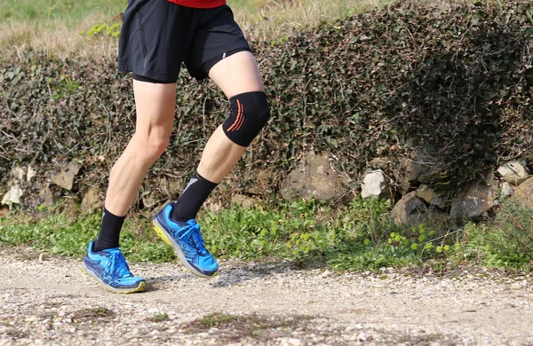Přespolní běžec během závodu se jeho kolena, zabalené — Stock fotografie
