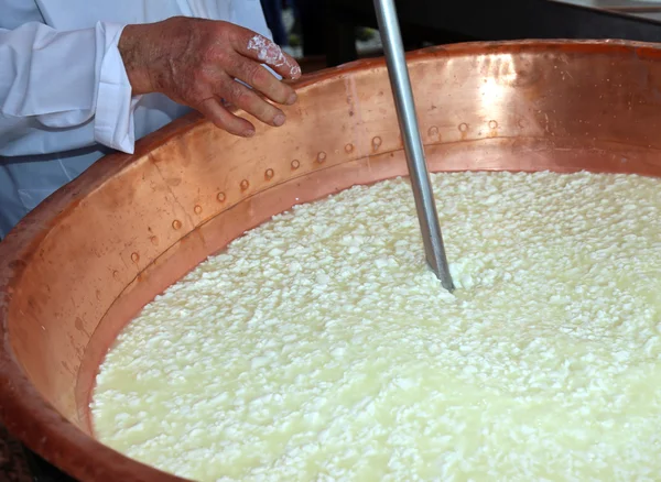 Quesero remueve la cuajada en el caldero para hacer queso — Foto de Stock