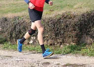 runner diz diz tarafından sarılmış ile arazi yarışı sırasında