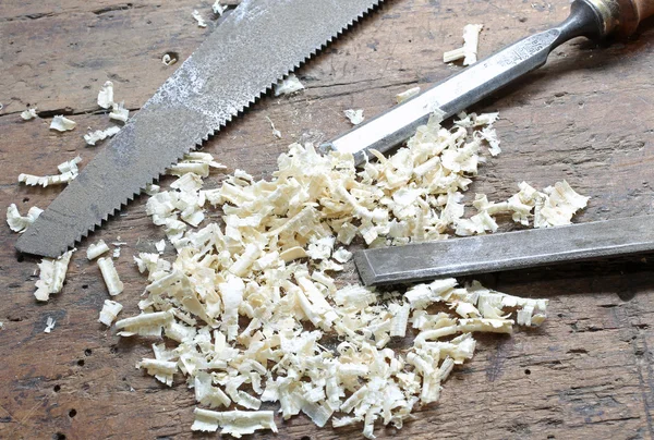 Zwei Meißel und eine Handsäge mit Holzspänen in der Werkbank — Stockfoto