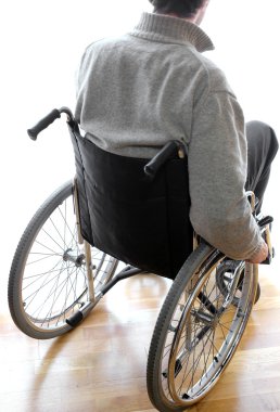 Odada bir tekerlekli sandalyede oturan devre dışı