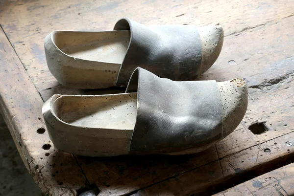 Dos viejos zuecos de madera de estilo holandés en el taller de un zapatero —  Fotos de Stock