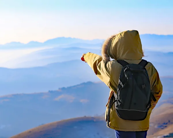 Explorador con mochila mira la vista desde la cima de una montaña —  Fotos de Stock