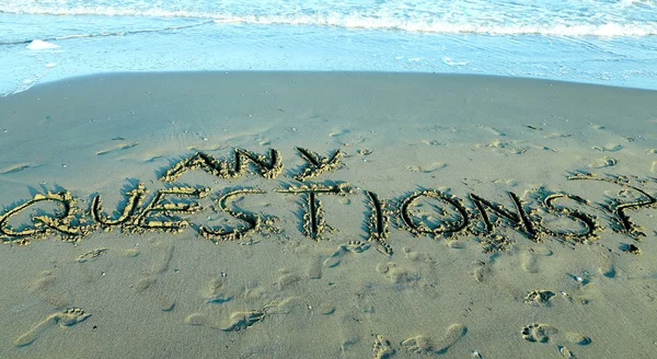 Vragen geschreven op het zand van de zee — Stockfoto