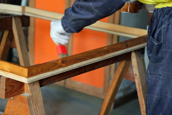 Плотник во время покраски старой деревянной рамы — стоковое фото