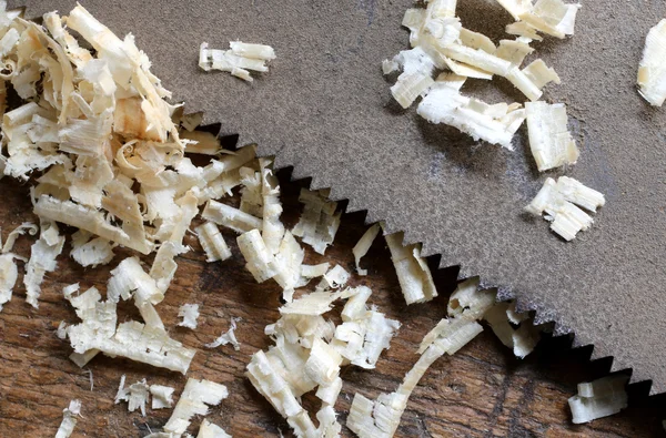 Detail of the blade of a saw toothed and sawdust chippings — Stock Photo, Image