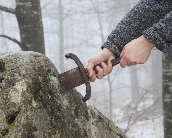 Cavaleiro tenta remover a espada Excalibur na pedra — Fotografia de Stock