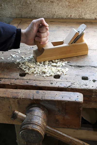 Mano del carpintero en el taller de carpintería con un plano —  Fotos de Stock