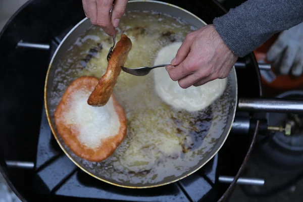 Cuocere le mani raccogliere la frittella dall'olio bollente — Foto Stock