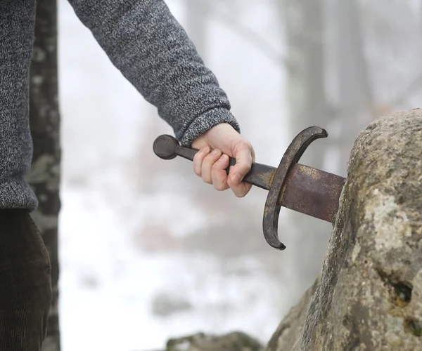 Caballero trata de quitar la espada Excalibur en la piedra —  Fotos de Stock