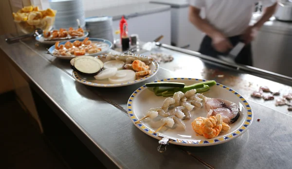 Pratos em um restaurante chinês com o cozinheiro no fundo — Fotografia de Stock