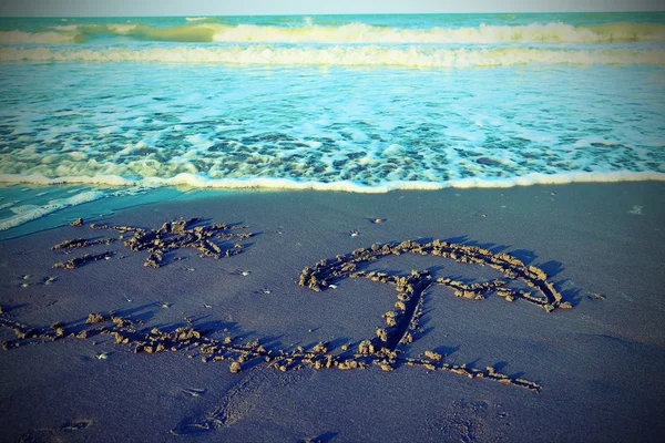 ビーチ パラソルと海の砂に描かれた太陽 — ストック写真