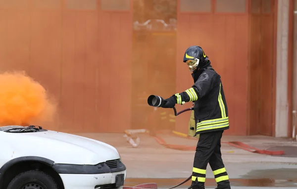 Vigili del fuoco durante l'esercizio per spegnere un incendio in un'auto — Foto Stock