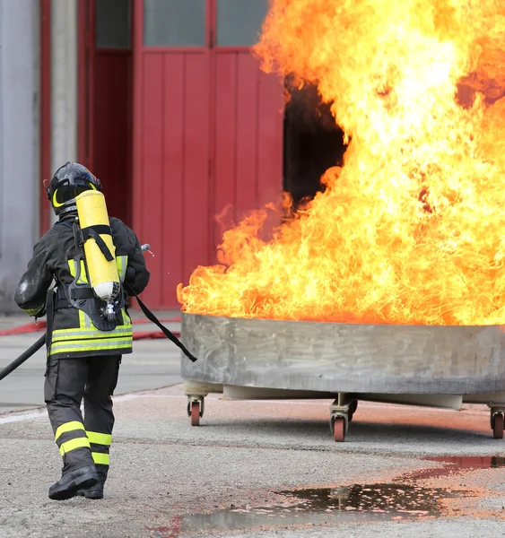 Bombeiros com garrafas de oxigênio fora do fogo durante um treinamento — Fotografia de Stock