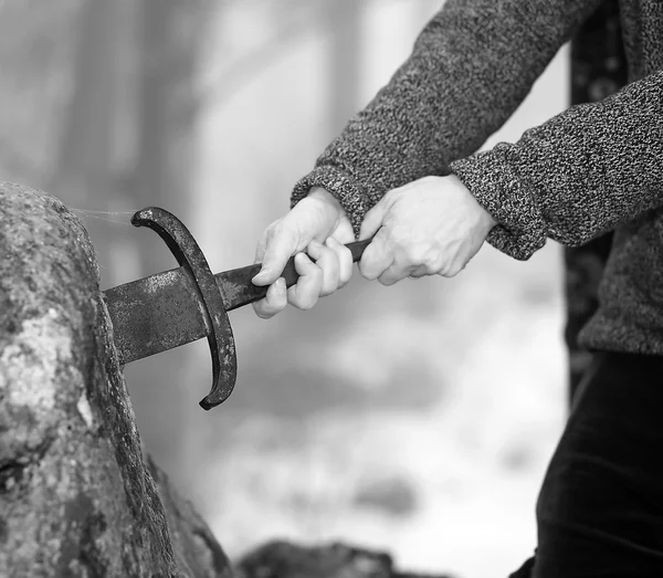 Caballero trata de quitar la espada Excalibur en la piedra — Foto de Stock