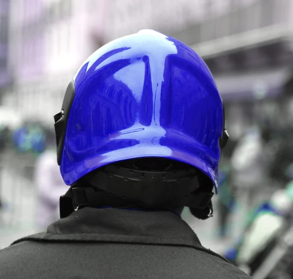 Policier avec le casque de protection bleu contrôle le peuple — Photo