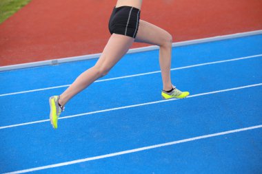genç kadın atlet atletik parça ile çalışan, uzun bacaklar 