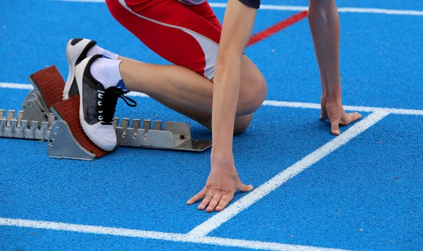 Athlète musclé dans les blocs de départ d'une piste athlétique befo — Photo