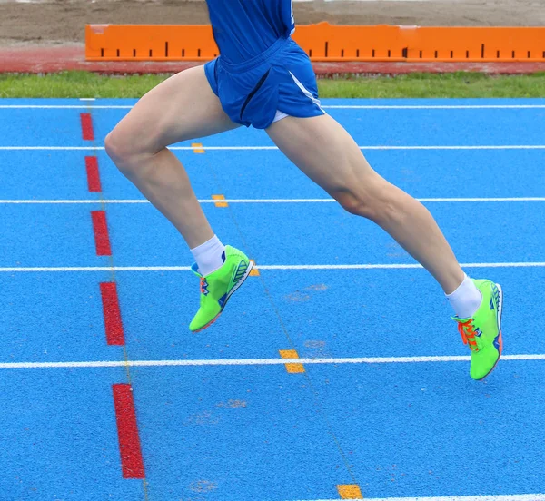 Jambes de coureur rapide court dans la piste d'athlétisme — Photo