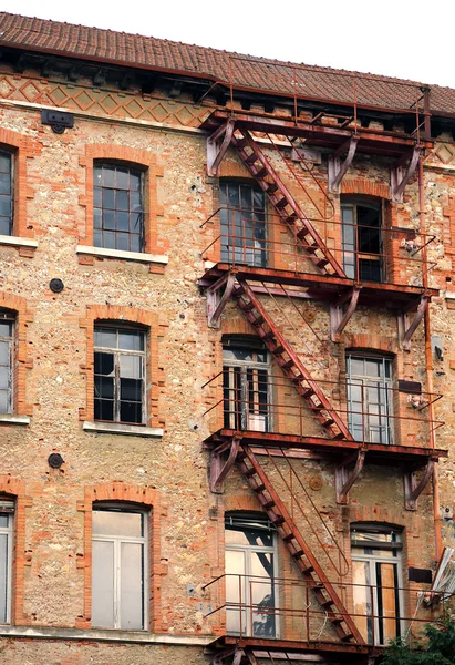 Longue sortie d'incendie rouillée dans un bâtiment industriel abandonné — Photo