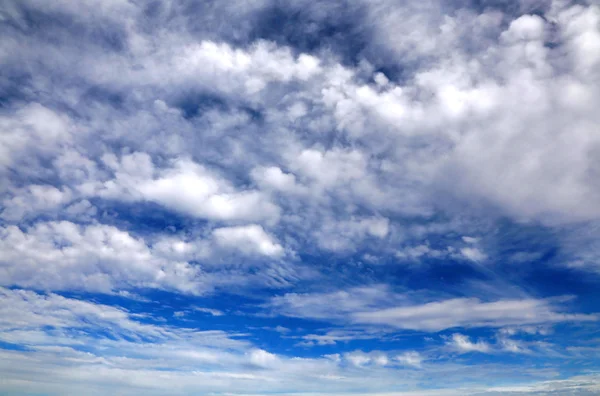 Nuvens brancas de todas as formas no céu azul — Fotografia de Stock