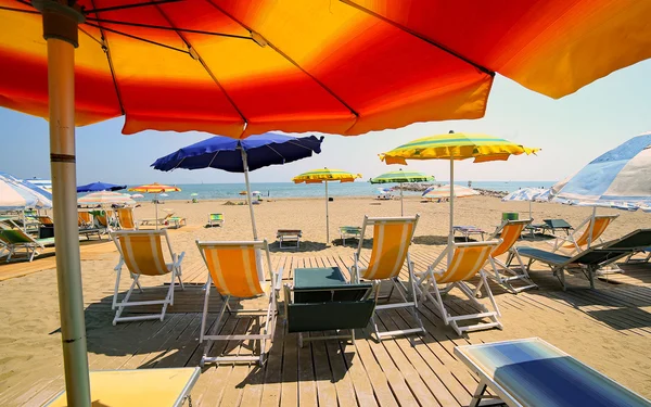 Sonnenschirme am Strand des Touristendorfes am Meer im Sommer — Stockfoto
