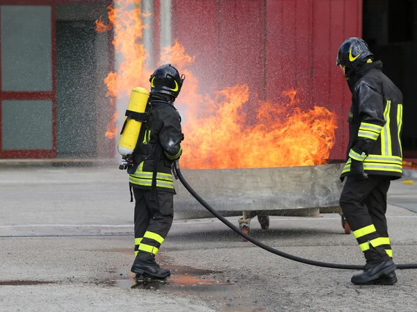 Bomberos con botellas de oxígeno fuera del fuego durante un entrenamiento —  Fotos de Stock