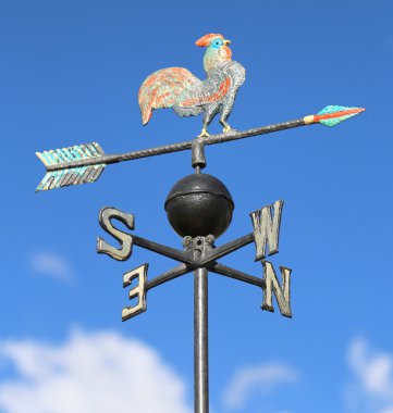  weathervane with rooster above an arrow and the four cardinal p clipart