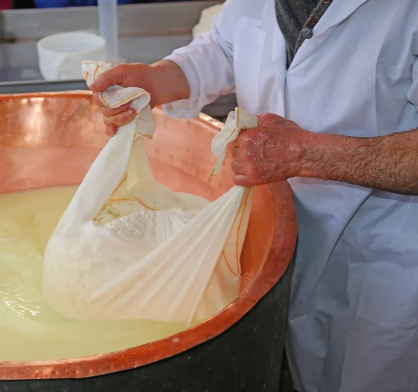 Senior cheesemaker samlar in osten med presenning från co — Stockfoto