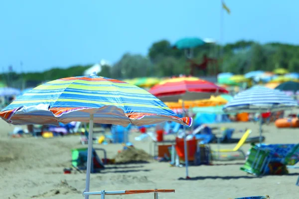 Playa cerca del mar. Sombrillas y tumbonas para relajarse —  Fotos de Stock