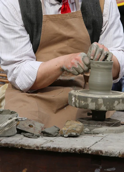 Potter z tokarka ręki podczas produkcji garnek z gliny — Zdjęcie stockowe