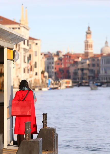 Elegancka Kobieta, ubrana na czerwono z czerwoną torebkę czeka na łodzi na G — Zdjęcie stockowe