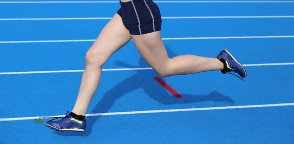 Mulher correndo na pista de atletismo — Fotografia de Stock