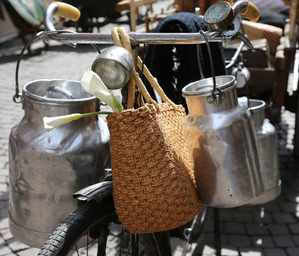 Aluminium milk cans transported on old bike — Stock Photo, Image