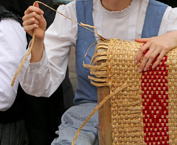 Young girl creates patiently a straw bag in the street — Stock Photo, Image