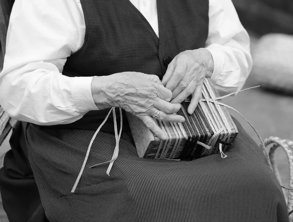 Handen van een bejaarde vrouw terwijl het creëren van een tas — Stockfoto