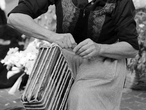 Oude vrouw die met haar handen werkt omwonden het stro maken een — Stockfoto