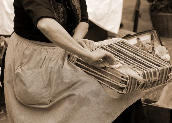 Stará žena s rukama vytváří ručně sáček — Stock fotografie